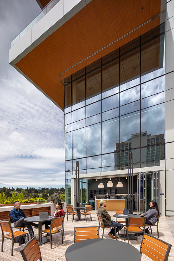 The terrace area of one of the 1001 Bellevue Office Buildings. People are sitting at tables and chairs.